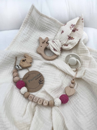 Personalizowana zawieszka do smoczka i szeleszczące uszka z muślinu to wyjątkowy zestaw dla niemowlęcia. Idealny prezent dla noworodka, wykonany z naturalnych materiałów. Idealny prezent na narodziny, baby shower lub chrzciny.