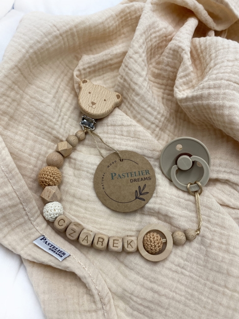 Personalizowana drewniana zawieszka do smoczka z koralików. Naturalne materiały, możliwość dodania imienia dziecka. Idealny prezent dla noworodka i niemowlęcia.