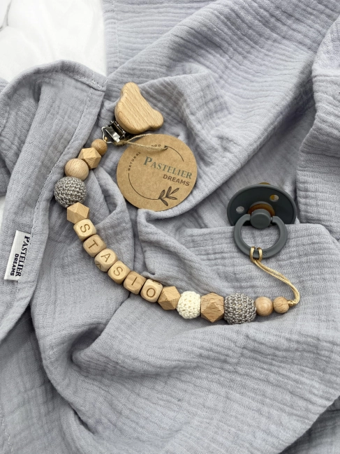 Personalizowana drewniana zawieszka do smoczka z koralików. Naturalne materiały, możliwość dodania imienia dziecka. Idealny prezent dla noworodka i niemowlęcia.