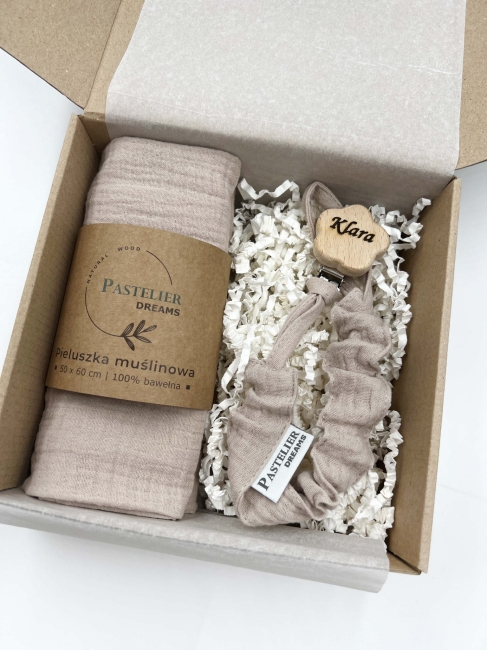 Personalizowana zawieszka do smoczka i pieluszka muślina to wyjątkowy zestaw dla niemowlęcia. Idealny prezent dla noworodka, wykonany z naturalnych materiałów. Idealny prezent na narodziny, baby shower lub chrzciny.