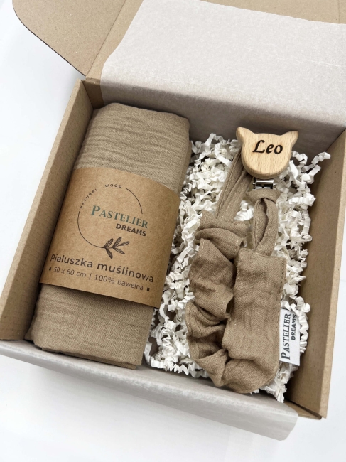 Personalizowana zawieszka do smoczka i pieluszka muślina to wyjątkowy zestaw dla niemowlęcia. Idealny prezent dla noworodka, wykonany z naturalnych materiałów. Idealny prezent na narodziny, baby shower lub chrzciny.