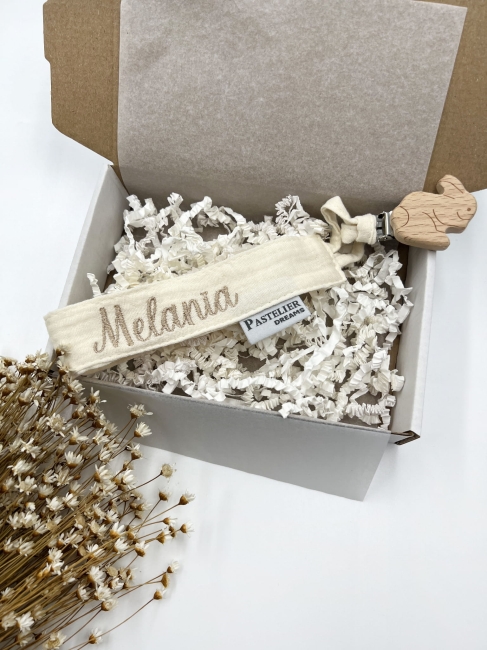Personalizowana zawieszka do smoczka z haftowanym imieniem i drewnianym klipsem. Praktyczny dodatek do wyprawki niemowlęcej i wyjątkowy prezent dla noworodka.