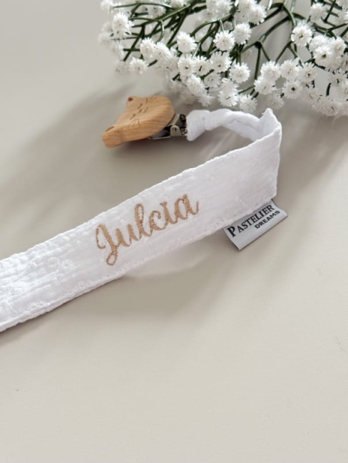 Personalizowana zawieszka do smoczka z haftowanym imieniem i drewnianym klipsem. Praktyczny dodatek do wyprawki niemowlęcej i wyjątkowy prezent dla noworodka.