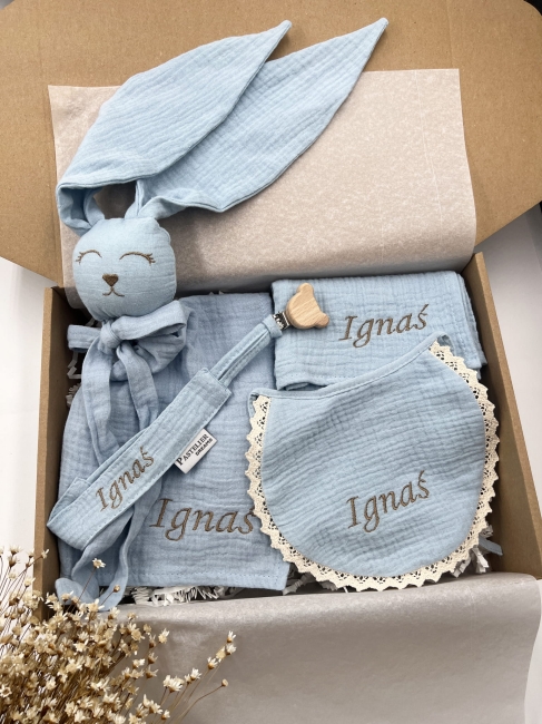 Box prezentowy dla noworodka z personalizowaną przytulanką króliczkiem z muślinu, zawieszką do smoczka z imieniem dziecka, śliniaczkiem z haftem oraz pieluszką muślinową z imieniem. Idealny prezent na narodziny, baby shower i chrzciny.