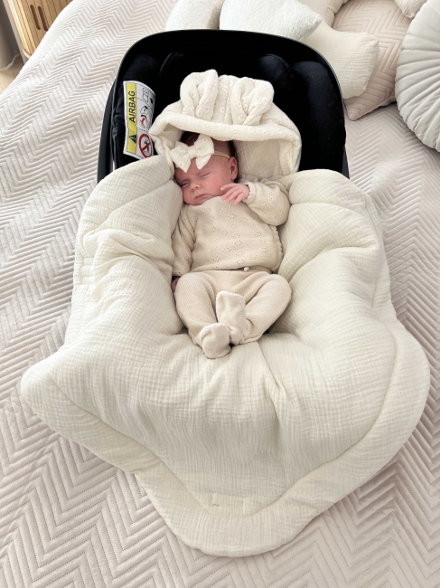 Muślinowy śpiworek do fotelika samochodowego dla niemowlaka – delikatne i wygodne otulenie podczas podróży i spacerów. Śpiworek do nosidełka to praktyczny element wyprawki dla dziecka, idealny na co dzień.