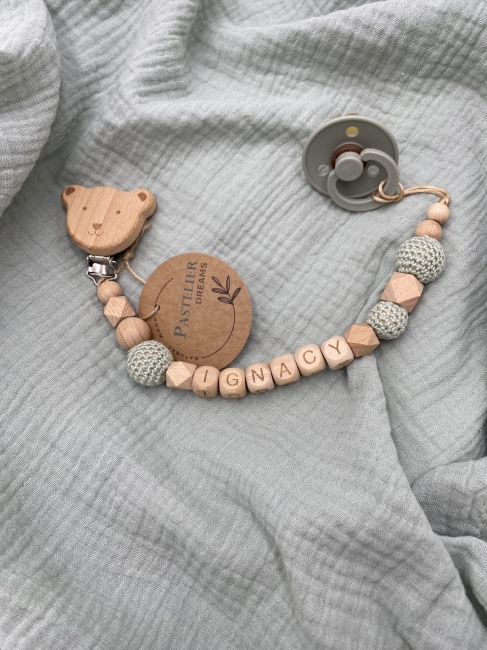 Personalizowana drewniana zawieszka do smoczka z koralików. Naturalne materiały, możliwość dodania imienia dziecka. Idealny prezent dla noworodka i niemowlęcia.