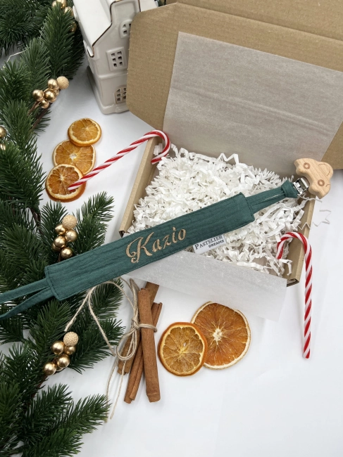 Personalizowana zawieszka do smoczka z haftowanym imieniem i drewnianym klipsem. Praktyczny dodatek do wyprawki niemowlęcej i wyjątkowy prezent dla noworodka.