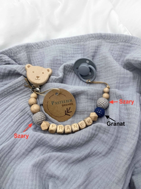 Personalizowana drewniana zawieszka do smoczka z koralików. Naturalne materiały, możliwość dodania imienia dziecka. Idealny prezent dla noworodka i niemowlęcia.