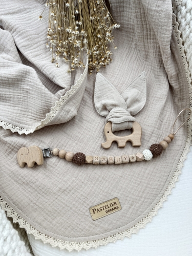 Personalizowana zawieszka do smoczka i szeleszczące uszka z muślinu to wyjątkowy zestaw dla niemowlęcia. Idealny prezent dla noworodka, wykonany z naturalnych materiałów. Idealny prezent na narodziny, baby shower lub chrzciny.