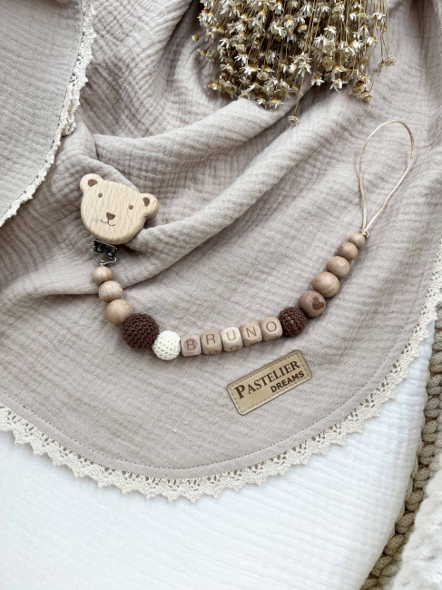 Personalizowana drewniana zawieszka do smoczka z koralików. Naturalne materiały, możliwość dodania imienia dziecka. Idealny prezent dla noworodka i niemowlęcia.