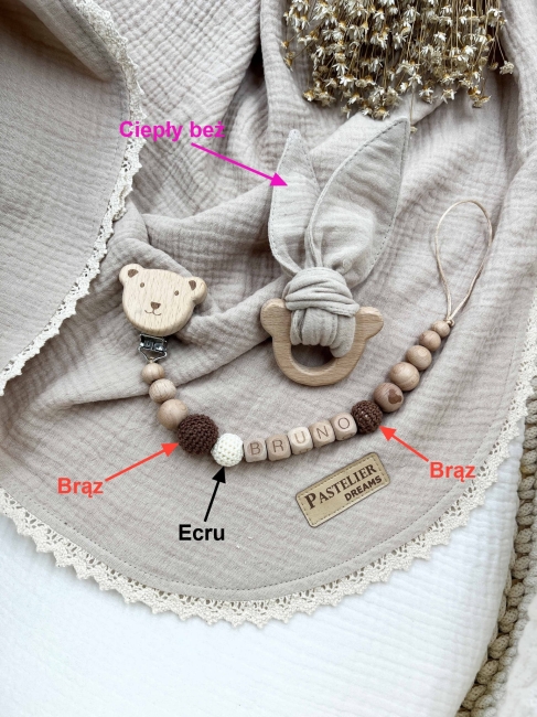 Personalizowana zawieszka do smoczka i szeleszczące uszka z muślinu to wyjątkowy zestaw dla niemowlęcia. Idealny prezent dla noworodka, wykonany z naturalnych materiałów. Idealny prezent na narodziny, baby shower lub chrzciny.