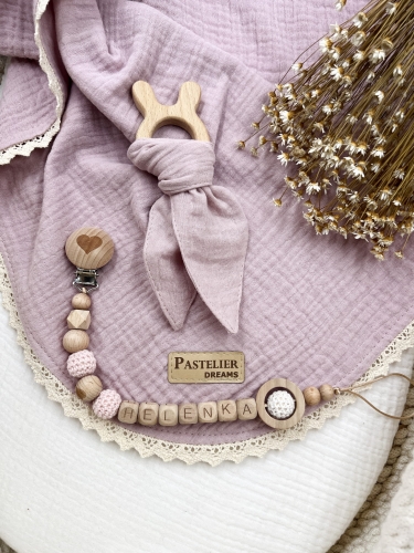 Personalizowana zawieszka do smoczka i szeleszczące uszka z muślinu to wyjątkowy zestaw dla niemowlęcia. Idealny prezent dla noworodka, wykonany z naturalnych materiałów. Idealny prezent na narodziny, baby shower lub chrzciny.