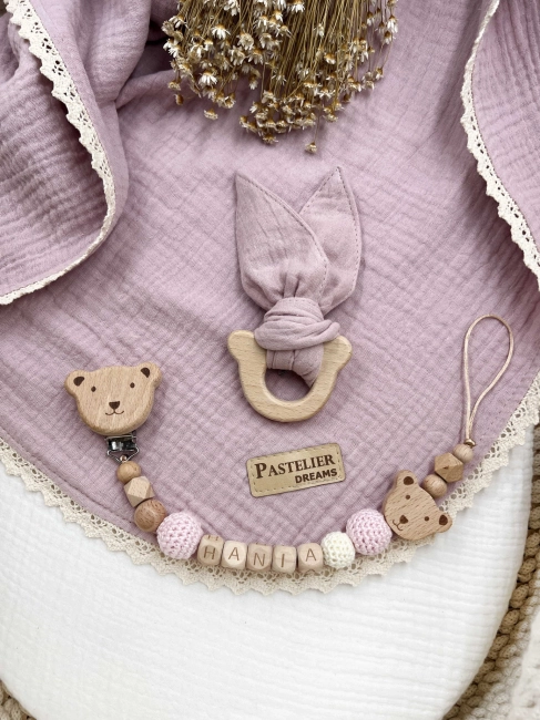 Personalizowana zawieszka do smoczka i szeleszczące uszka z muślinu to wyjątkowy zestaw dla niemowlęcia. Idealny prezent dla noworodka, wykonany z naturalnych materiałów. Idealny prezent na narodziny, baby shower lub chrzciny.