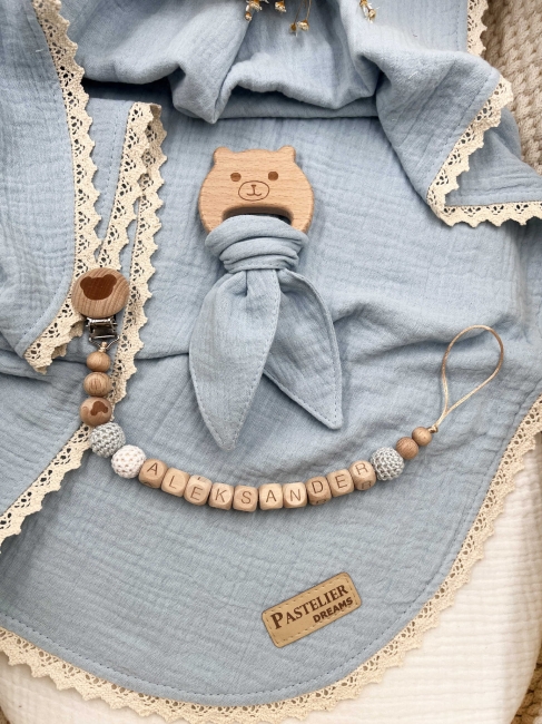 Personalizowana zawieszka do smoczka i szeleszczące uszka z muślinu to wyjątkowy zestaw dla niemowlęcia. Idealny prezent dla noworodka, wykonany z naturalnych materiałów. Idealny prezent na narodziny, baby shower lub chrzciny.