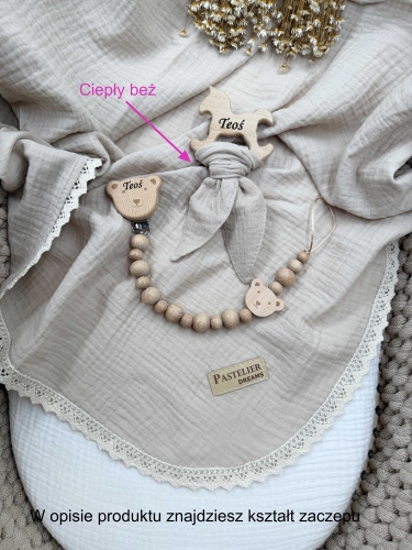 Personalizowana zawieszka do smoczka i szeleszczące uszka z muślinu to wyjątkowy zestaw dla niemowlęcia. Idealny prezent dla noworodka, wykonany z naturalnych materiałów. Idealny prezent na narodziny, baby shower lub chrzciny.