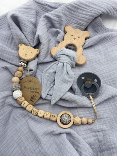 Personalizowana zawieszka do smoczka i szeleszczące uszka z muślinu to wyjątkowy zestaw dla niemowlęcia. Idealny prezent dla noworodka, wykonany z naturalnych materiałów. Idealny prezent na narodziny, baby shower lub chrzciny.
