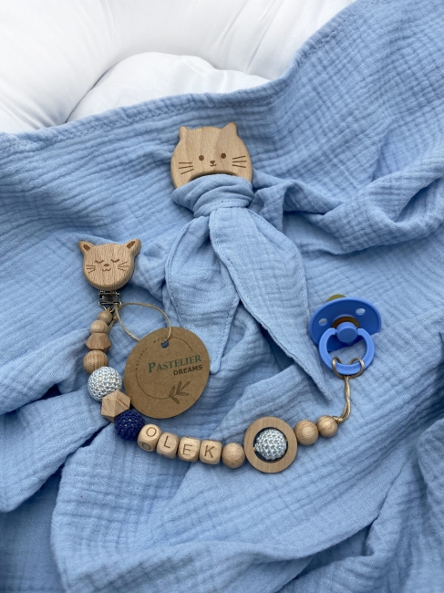 Personalizowana zawieszka do smoczka i szeleszczące uszka z muślinu to wyjątkowy zestaw dla niemowlęcia. Idealny prezent dla noworodka, wykonany z naturalnych materiałów. Idealny prezent na narodziny, baby shower lub chrzciny.