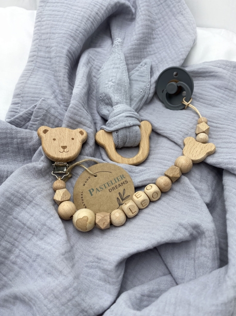 Personalizowana zawieszka do smoczka i szeleszczące uszka z muślinu to wyjątkowy zestaw dla niemowlęcia. Idealny prezent dla noworodka, wykonany z naturalnych materiałów. Idealny prezent na narodziny, baby shower lub chrzciny.