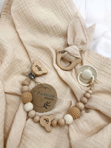 Personalizowana zawieszka do smoczka i szeleszczące uszka z muślinu to wyjątkowy zestaw dla niemowlęcia. Idealny prezent dla noworodka, wykonany z naturalnych materiałów. Idealny prezent na narodziny, baby shower lub chrzciny.