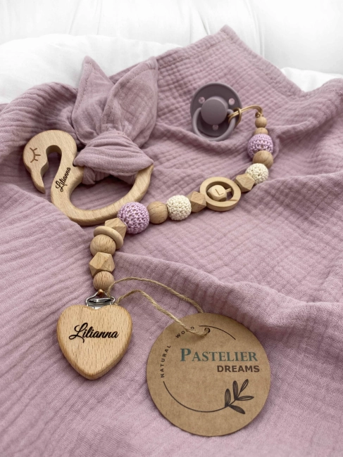 Personalizowana zawieszka do smoczka i szeleszczące uszka z muślinu to wyjątkowy zestaw dla niemowlęcia. Idealny prezent dla noworodka, wykonany z naturalnych materiałów. Idealny prezent na narodziny, baby shower lub chrzciny.