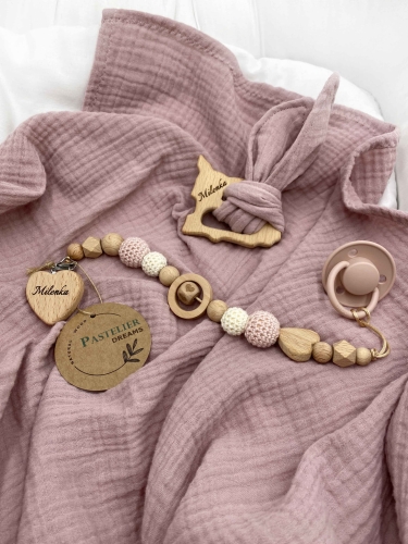 Personalizowana zawieszka do smoczka i szeleszczące uszka z muślinu to wyjątkowy zestaw dla niemowlęcia. Idealny prezent dla noworodka, wykonany z naturalnych materiałów. Idealny prezent na narodziny, baby shower lub chrzciny.