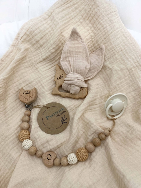 Personalizowana zawieszka do smoczka i szeleszczące uszka z muślinu to wyjątkowy zestaw dla niemowlęcia. Idealny prezent dla noworodka, wykonany z naturalnych materiałów. Idealny prezent na narodziny, baby shower lub chrzciny.