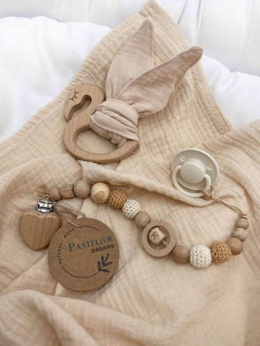 Personalizowana zawieszka do smoczka i szeleszczące uszka z muślinu to wyjątkowy zestaw dla niemowlęcia. Idealny prezent dla noworodka, wykonany z naturalnych materiałów. Idealny prezent na narodziny, baby shower lub chrzciny.