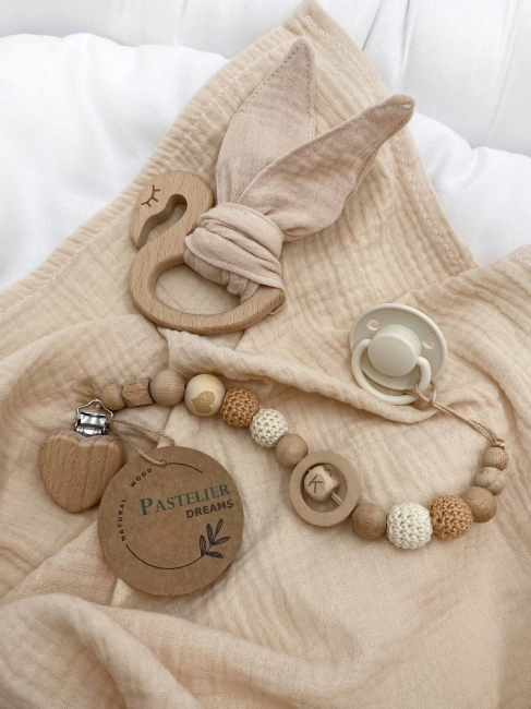 Personalizowana zawieszka do smoczka i szeleszczące uszka z muślinu to wyjątkowy zestaw dla niemowlęcia. Idealny prezent dla noworodka, wykonany z naturalnych materiałów. Idealny prezent na narodziny, baby shower lub chrzciny.