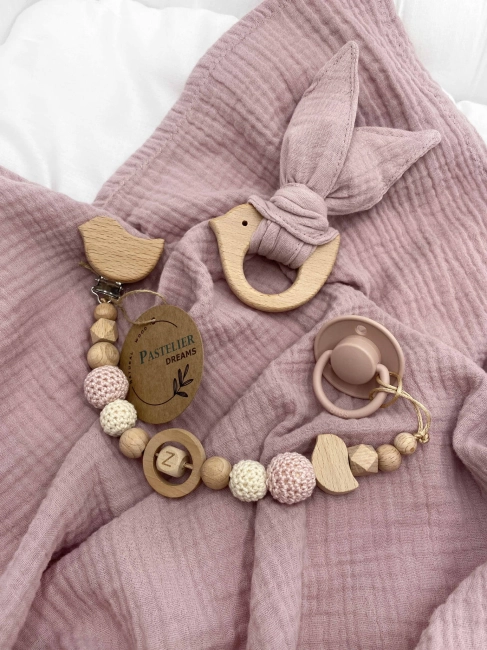 Personalizowana zawieszka do smoczka i szeleszczące uszka z muślinu to wyjątkowy zestaw dla niemowlęcia. Idealny prezent dla noworodka, wykonany z naturalnych materiałów. Idealny prezent na narodziny, baby shower lub chrzciny.