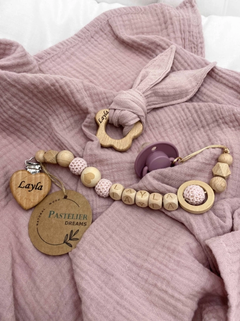 Personalizowana zawieszka do smoczka i szeleszczące uszka z muślinu to wyjątkowy zestaw dla niemowlęcia. Idealny prezent dla noworodka, wykonany z naturalnych materiałów. Idealny prezent na narodziny, baby shower lub chrzciny.