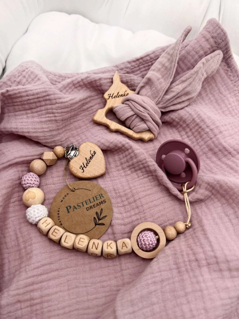 Personalizowana zawieszka do smoczka i szeleszczące uszka z muślinu to wyjątkowy zestaw dla niemowlęcia. Idealny prezent dla noworodka, wykonany z naturalnych materiałów. Idealny prezent na narodziny, baby shower lub chrzciny.