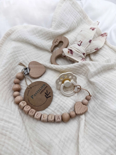 Personalizowana zawieszka do smoczka i szeleszczące uszka z muślinu to wyjątkowy zestaw dla niemowlęcia. Idealny prezent dla noworodka, wykonany z naturalnych materiałów. Idealny prezent na narodziny, baby shower lub chrzciny.