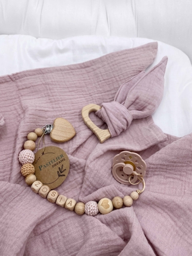 Personalizowana zawieszka do smoczka i szeleszczące uszka z muślinu to wyjątkowy zestaw dla niemowlęcia. Idealny prezent dla noworodka, wykonany z naturalnych materiałów. Idealny prezent na narodziny, baby shower lub chrzciny.