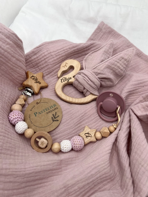 Personalizowana zawieszka do smoczka i szeleszczące uszka z muślinu to wyjątkowy zestaw dla niemowlęcia. Idealny prezent dla noworodka, wykonany z naturalnych materiałów. Idealny prezent na narodziny, baby shower lub chrzciny.