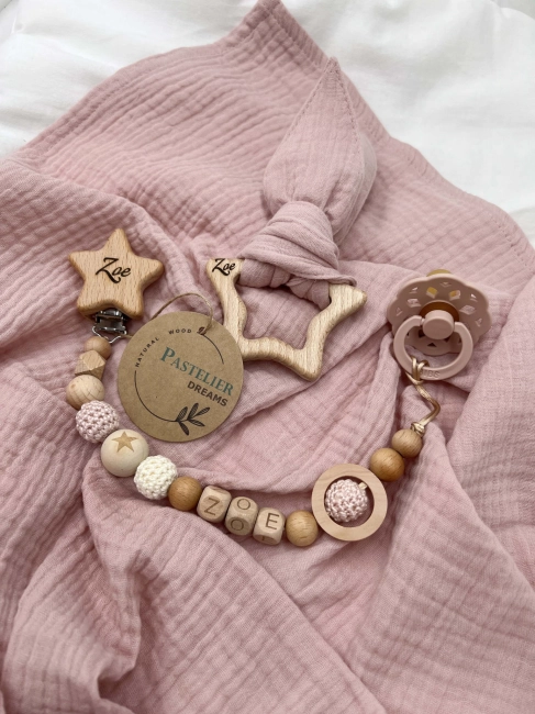 Personalizowana zawieszka do smoczka i szeleszczące uszka z muślinu to wyjątkowy zestaw dla niemowlęcia. Idealny prezent dla noworodka, wykonany z naturalnych materiałów. Idealny prezent na narodziny, baby shower lub chrzciny.